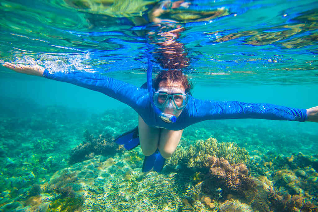 mulher embaixo da água praticando mergulho com snorkel