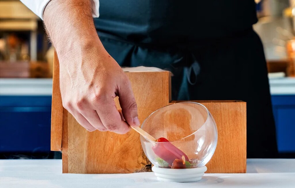 chefe preparando prato do Evvai, um dos restaurantes Michelin em SP