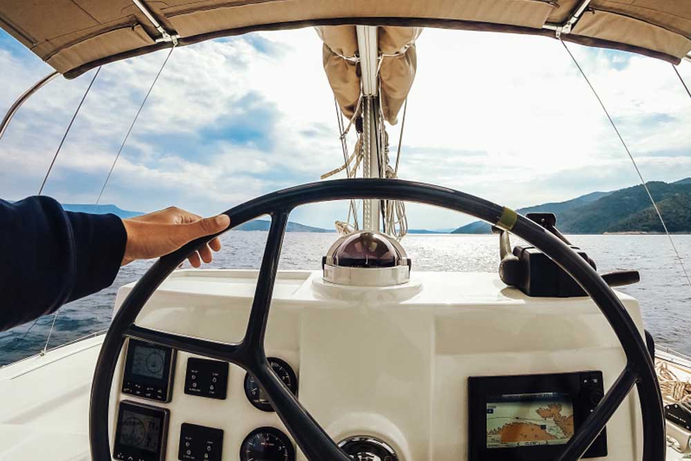 pessoa pilotando embarcação, representando o consumo de gasolina da lancha