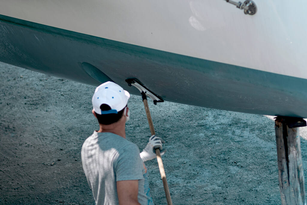 profissional fazendo a manutenção da cor para casco de barco