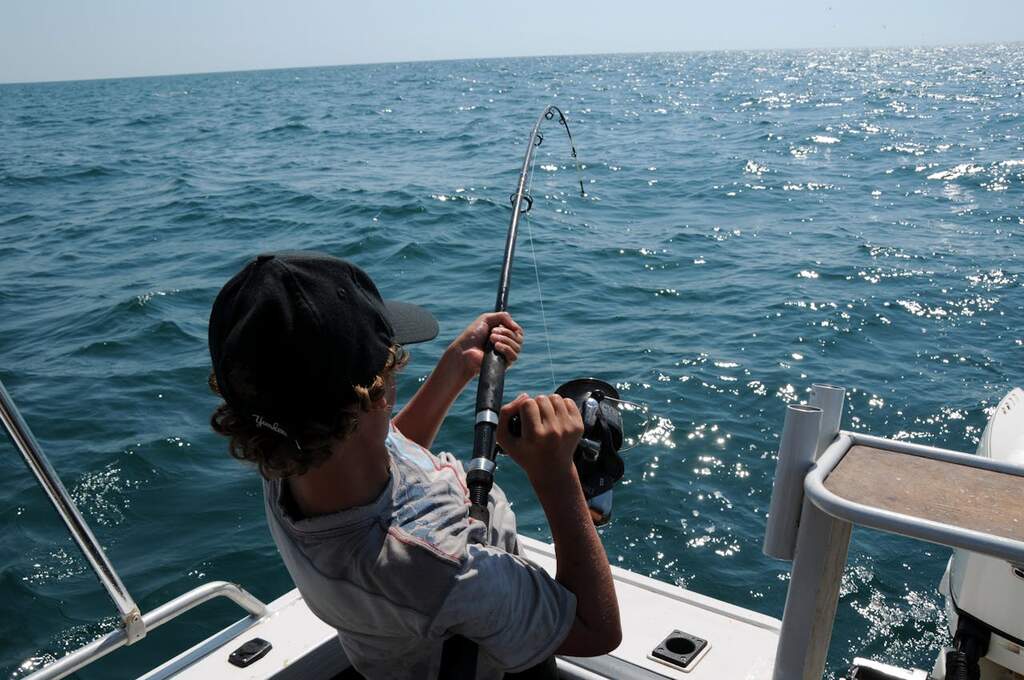 pessoa em barco praticando um dos tipos de pesca